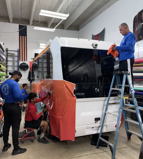Crew installing a shuttle bus wrap